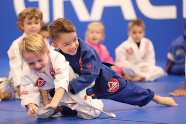 Young children in white and blue gis grappling during a Tiny Champions class, Fleming Island FL